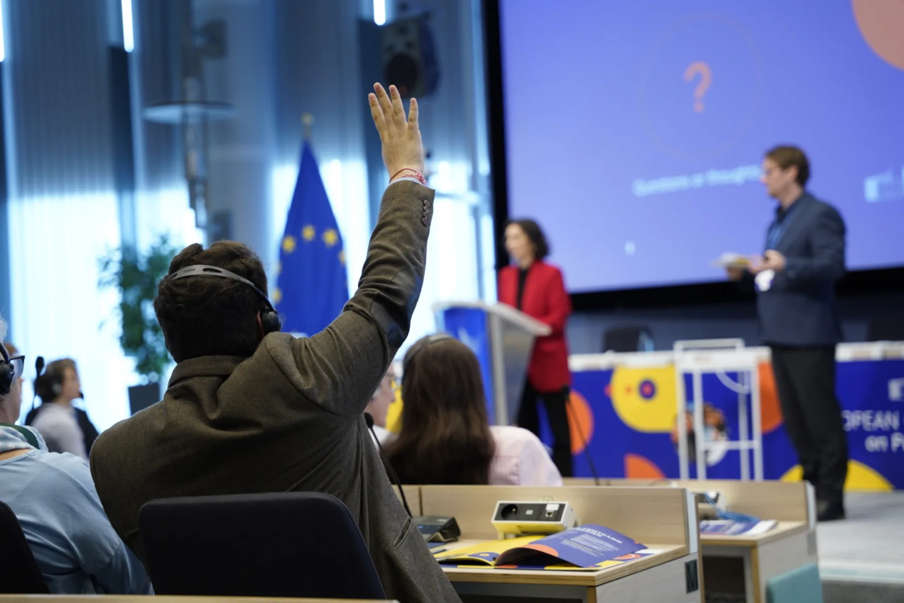 Participant raises a hand during a European citizens’ panel