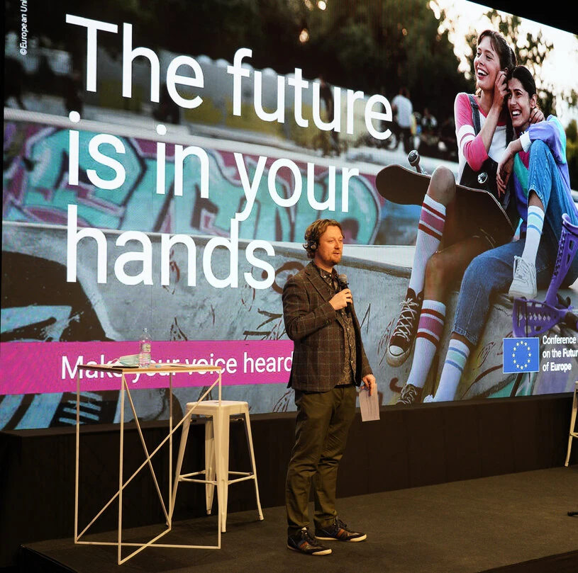 Mark moderating on stage at a European conference